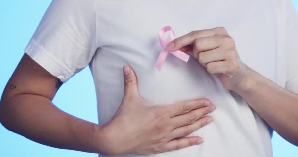 ピンクリボン 乳がん 健康のための青の背景にスタジオの男性との意識 10月に認定の弓 シンボルまたは記号を置く男性と胸 医療や医療 — ストック動画