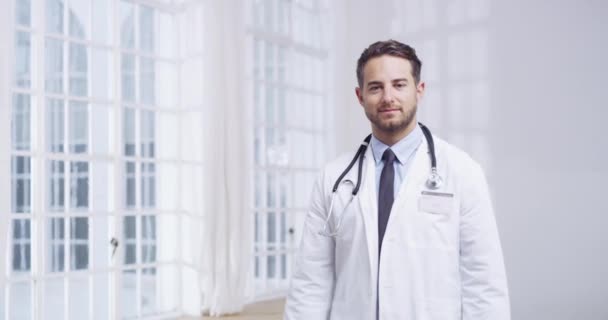 一位双手交叉的医生站在医院的办公室里 他的脸上洋溢着快乐 成功的表情 医学专业男性医务工作者的自信 微笑与形象塑造 — 图库视频影像