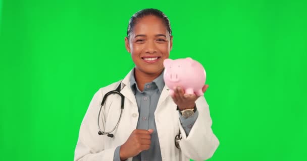 医療投資や保険の予算を親指アップと貯蓄 ピギーバンク 医師と緑の画面 お金を節約します ファイナンスと幸せな顔の医療ラテン女性とともにはい手上のスタジオの背景 — ストック動画