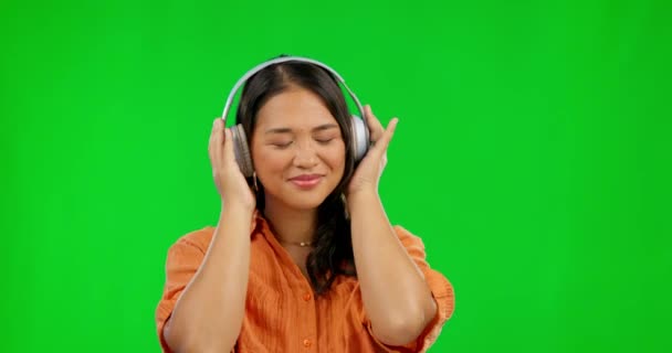 背景のモックアップに隔離されたスタジオで緑の画面上の音楽のヘッドフォン 幸せと女性 ラジオ リスニング アジア人は オーディオ サウンドやジャズポッドキャスト ヒップホップやダンスをストリーミングプレイリストにストリーミング — ストック動画