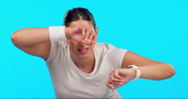 一个女人在擦汗 在工作室精疲力竭的时候带着手表 田径运动员在蓝色背景下锻炼后检查进展 表现或失败情况 — 图库视频影像