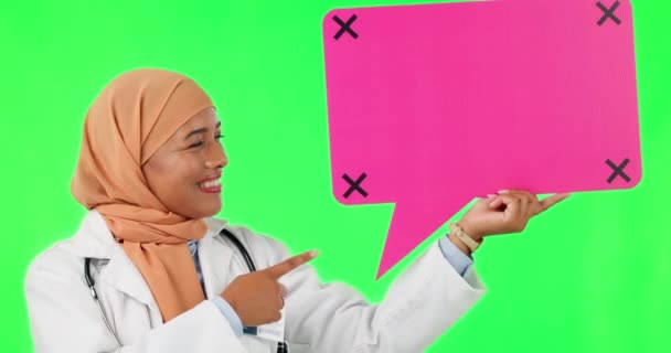スタジオの背景を背景に 緑色の画面にスピーチバブルでイスラム教徒の女性 そして大丈夫なサイン 絵文字やOkソーシャルメディアチャットなどのアイコンを指す女性医療専門家の肖像画 — ストック動画