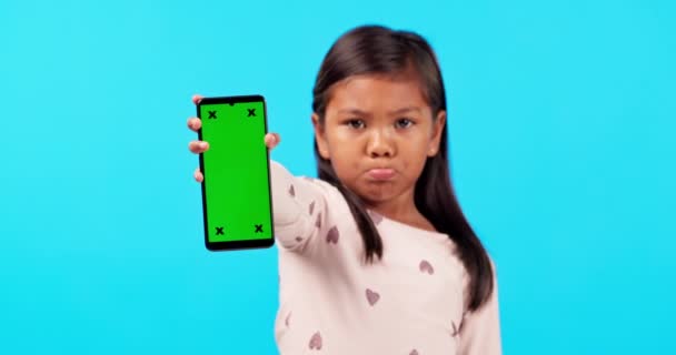 绿色屏幕和一个不快乐的女孩在工作室的蓝色背景的营销或广告 品牌和一个喜怒无常的孩子拿着铬钥匙 在一个空白的显示屏上跟踪标记 — 图库视频影像