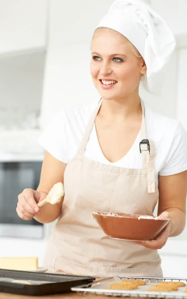 Happy woman, thinking or chef baking cookies with dough or pastry in a bakery kitchen with recipe. Food business, ideas or girl baker working in preparation of a sweet meal, dessert tray or biscuit.