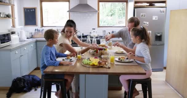 家族は朝食 健康的な食べ物や栄養を食べ 幸せな人々と一緒に時間を過ごすとキッチンでリラックスします 子供や幸せと朝の食事の上に結合 愛と家庭でのケア — ストック動画