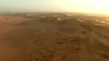 Dubai, çöl dronu ya da günbatımı için kum manzarası, karadaki doğa güzelliği, ufuk çizgisi ya da Afrika sahara. Tepe, toprak ya da özgürlük Suudi Arabistan 'da, çorak arazide ya da yaz gündoğumunda sabah güneşinde.