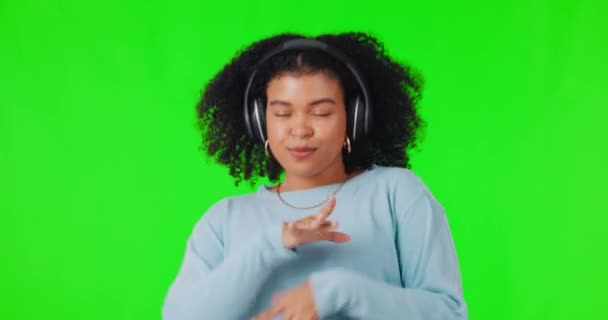 耳机和一个女人在绿色的屏幕上快乐地跳舞 精力充沛地订阅 在演播室背景上跳舞 听音频或广播以寻求自我爱或自由的非洲女性 — 图库视频影像