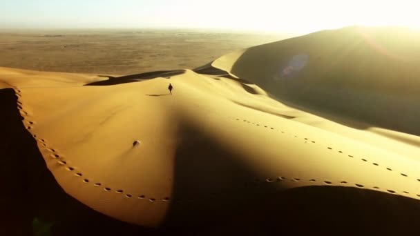 日落时的旅行 沙漠和人物形象 以及前往目的地 自由或夏季旅行的无人驾驶飞机 在迪拜度假时 与人在沙丘地平线上的足迹 冒险和旅行 — 图库视频影像