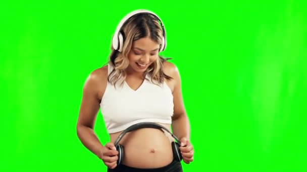 孕妇或耳机在工作室的胃为成长或婴儿发育在绿色屏幕上 孕期音乐 放松或母亲在腹部放音 以促进生育健康 — 图库视频影像