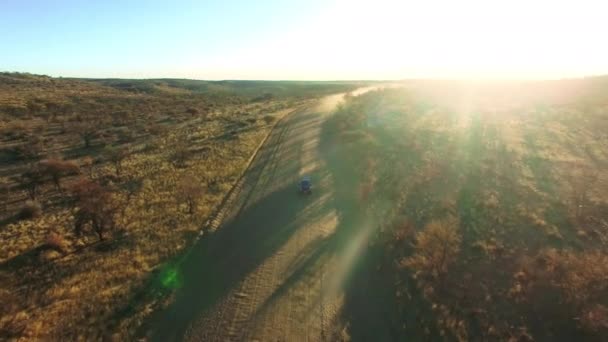 輸送または旅のためのオーストラリアの砂の田舎の未舗装道路のトラックで旅行 日没と砂漠 ドライブ ほこりや自然のためのロードトリップにSuv車と冒険 風景やドローン — ストック動画