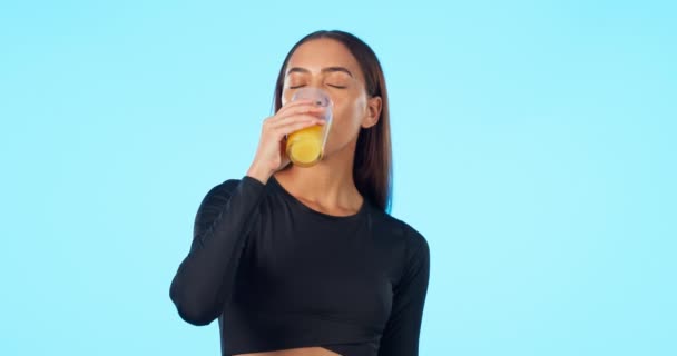 食事や栄養のためのジュースを持つ女性の幸せ 青の背景と顔 ビタミンCとモックアップスタジオの背景に隔離された健康的なフルーツドリンクと若い女の子の肖像画 — ストック動画