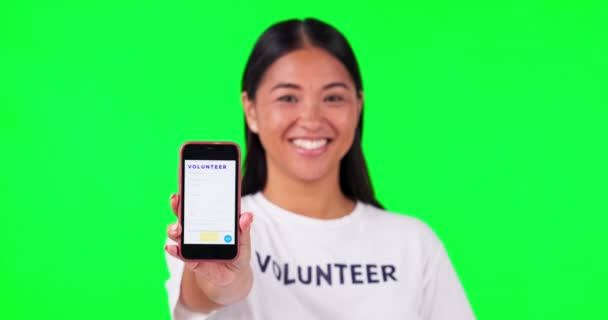 慈善ウェブサイトの資金情報のための緑の画面の背景に電話 ボランティア 非営利の連絡先 Ngoアプリや寄付やUiモックアップのためのスマートフォンやTシャツを持つアジア人の手 — ストック動画