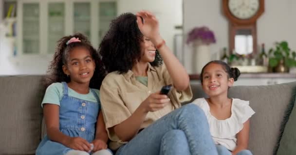 母亲和孩子们坐在沙发上 在他们家的客厅里看电影 快乐和年轻的妈妈抱着她的女儿在家里一起表演 — 图库视频影像