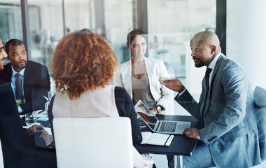 İş adamları, şirket ekibiyle toplantı, dizüstü bilgisayar ve yönetim grubuyla atölye çalışması. Yönetici erkekler, kadınlar ve CEO ile çeşitlilik, mali strateji ve masa başında planlama tartışması.