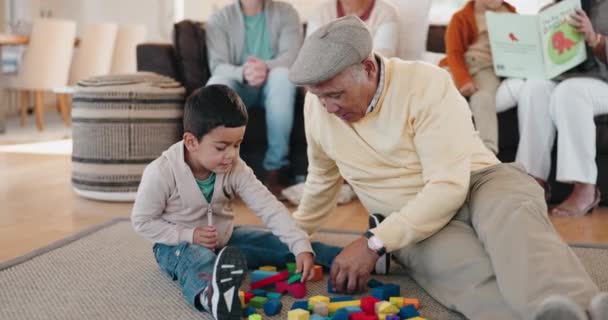 建物のブロックと祖父は自宅訪問中にリビングルームで彼の孫と遊んでいます 愛または学習おもちゃで老人ボンディングとともに彼の少年孫床の上に — ストック動画