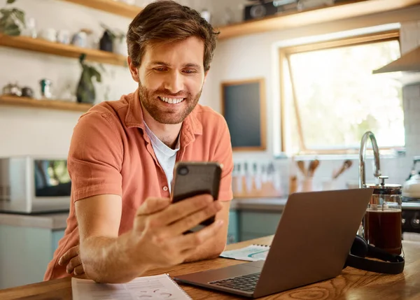 幸せな男 電話やソーシャルメディアのためのチャット 自宅でキッチンテーブル上の通信やネットワーク オンライン閲覧 研究や家の中でテキストメッセージのためのモバイルスマートフォンアプリ上で笑顔を持つ男性 — ストック写真