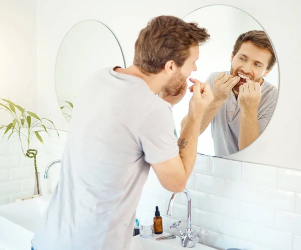 歯科フロス 朝のルーチンとセルフケア 口腔衛生と歯のためのバスルームで男と鏡 美しさ 健康と反射のために自宅で男性の顔と掃除 笑顔と健康 — ストック写真