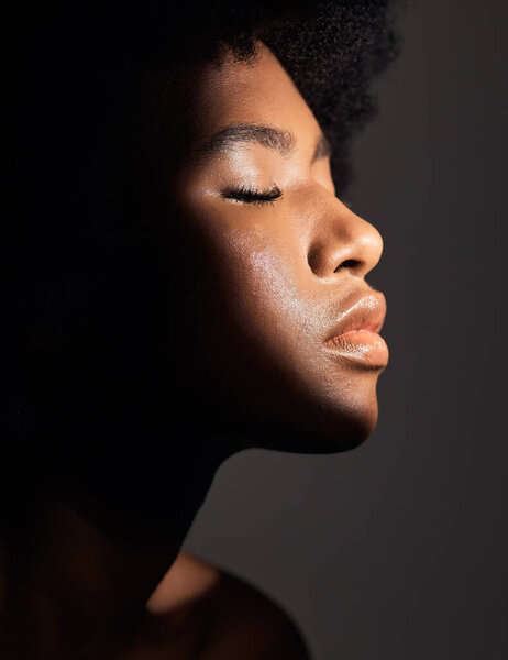 Face shadow, light and black woman with beauty, natural skincare glow and calm with facial cosmetics routine. Wellness profile, dermatology and African studio person with self care on grey background.