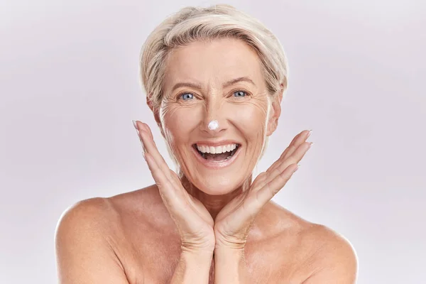 皮肤护理 肖像和成熟的妇女与奶油在脸上为抗衰老 皮肤科和胶原蛋白的白色背景 快乐的高级模特 用乳液或防晒霜在美容品工作室里 — 图库照片