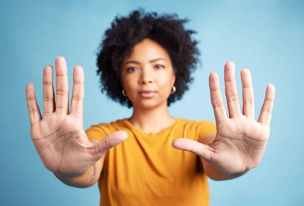 Portrait, stop hands and serious woman in studio isolated on a blue background. African person, face and ban, rejection or warning, refuse and no palm sign to protest racism, human rights and emoji
