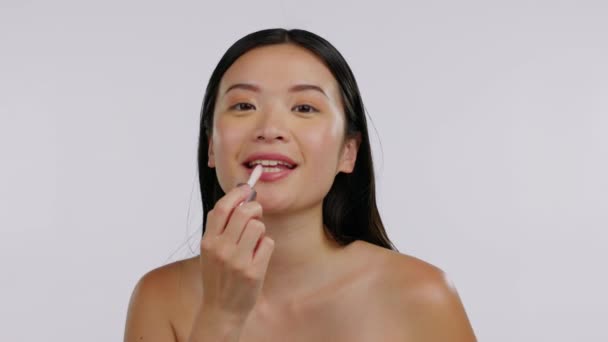 アジアの女性 顔と美しさ 口紅と肖像画で幸せ 白い背景に皮膚や化粧品 皮膚科 スキンケア モックアップスペースと女性モデルは唇に化粧品を適用します — ストック動画