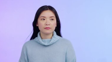 Asyalı bir kadın, endişeli, korku ve endişe dolu bir yüz ifadesiyle mor bir stüdyo arka planında izole edilmiş. Üzgün, kaygılı ya da üzgün model ve depresyon, kriz ya da travma geçiren kişi.