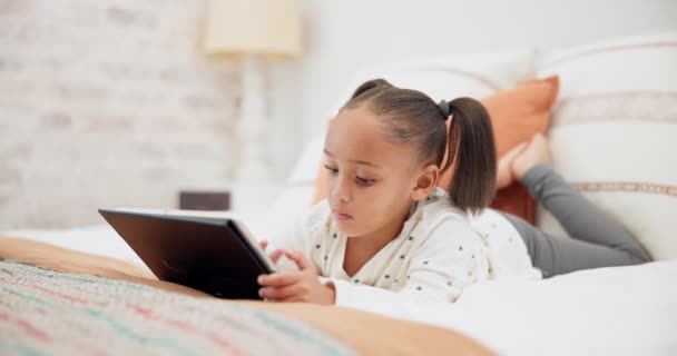 オンラインゲームをプレイしたり インターネット上でビデオを見てベッドの上でデジタルタブレット リラックスして子供 テクノロジー 休息と自宅で寝室でソーシャルメディアやモバイルアプリ上の若い女の子の子供のネットワーキング — ストック動画