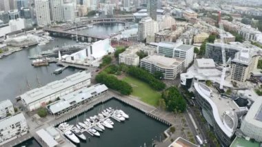 Sidney şehrinin tekne, binaları ve insansız hava aracı Avustralya 'da altyapısı, gökdeleni ve manzarası var. Okyanus, seyahat ya da şehir manzarası, deniz kenarı ve kalkınma için limana havadan bakan yat manzaralı şehir..