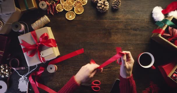 圣诞礼物 手和照片都要用蝴蝶结和彩带包扎 用于创业广告 以上木制桌子 附有度假套件或赠送创意图片 供电话应用文具销售 — 图库视频影像