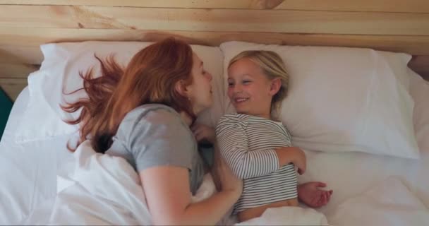 和一个母亲亲吻她的女儿在早上睡在他们的家里 与躺在卧室里的妇女和女孩在一起时 放松或早点 — 图库视频影像