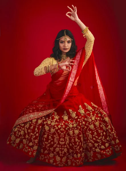 赤いスタジオの背景にファッション 伝統的なドレスやお祝いと肖像画 ダンスやインドの女性 女性の人や文化的な服 ジュエリーや美しさと踊りとモデル — ストック写真