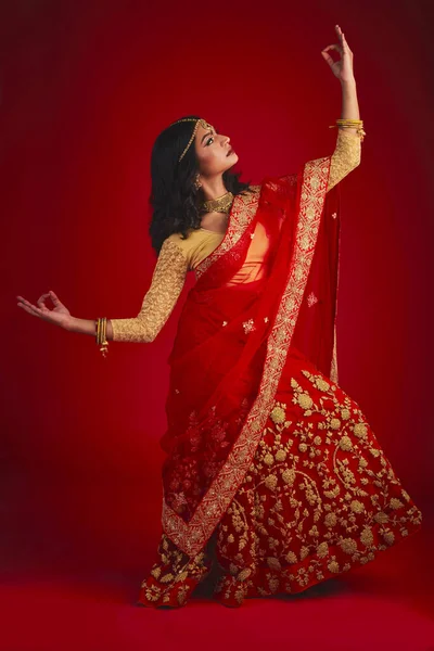 赤いスタジオの背景に伝統的なドレス 美しさとお祝いのファッション ダンサーとインドの女性 文化的な衣装を着た女の子とモデル 宗教と踊りと自信 — ストック写真