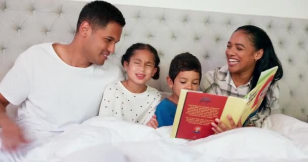 父母和孩子们在卧室里看书 快乐的家庭在家里学习 爸爸和孩子们和爱 关心和讲故事的时间一起躺在床上休息 — 图库视频影像