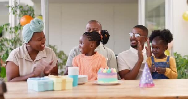 誕生日 子供パーティー 自宅で女の子の子供を祝う黒の家族との拍手 マイルストーンイベントでケーキの上にろうそくを吹いている間に両親 祖父母 子供たちが拍手をする — ストック動画
