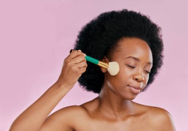 Siyah kadın, güzel ve ciltli fırça ve makyaj, pembe arka planda temel ya da toz uygulaması. Kozmetik aletler, cilt bakımı ve Afrika model parıltısı, kozmetoloji ve yüz bakımı, stüdyoda kişisel bakım..