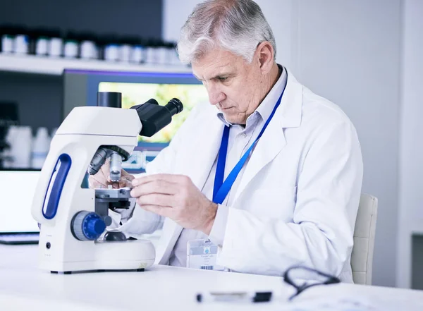 stock image Mature scientist, man and microscope, review and analysis for science study, medical research and biotechnology in lab. Male person, doctor and pathology, check test sample with scientific experiment.