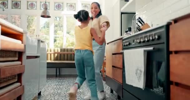 和她的孩子在厨房里的妈妈在家里跳音乐 弹奏音乐或收音机 年轻的妈妈在家里和女儿一起唱歌跳舞 — 图库视频影像