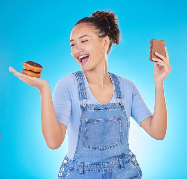 饮食和快乐的女人与糖果在工作室 巧克力和甜甜圈的蓝色背景的饮食计划 营养和减肥的选择 带着微笑的女孩 糖或甜点的自由 — 图库照片