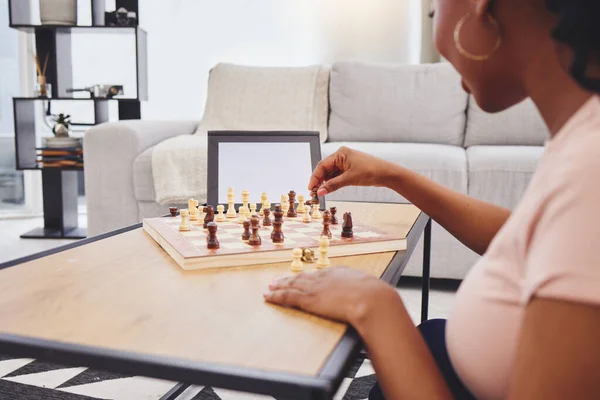 Video call, chess and woman in home with tablet, mockup and screen for gaming connection in lounge. Thinking, internet and chessboard, virtual strategy board game and African girl problem solving