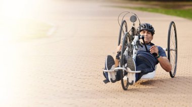 Özürlü, motosikletli ve spor için açık havada bisikleti olan bir adam, yarış ya da spor fişeği gibi parlayan bir egzersiz gücü. Fitness, belden aşağısı felçli erkek sporcu ve bisiklet yarışması, meydan okuma ya da yarışma.