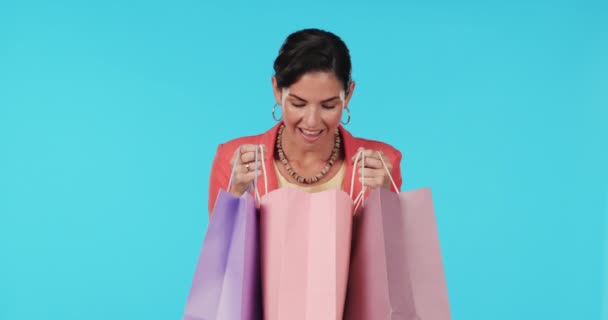 购物袋或快乐的女人兴奋或惊讶在工作室蓝色背景的奖品 面容肖像 微笑或因打折或促销而带着时尚礼物或产品的震惊女孩 — 图库视频影像