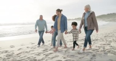 Mutlu, el ele tutuşan ve sahilde yürüme, kaynaşma ve tatil için ırklar arası aile. Gülümse, konuş ve ebeveynler, büyükanne ve büyükbaba ve çocuklar bir yürüyüş için sevgiyle, seyahat ve rahatla.