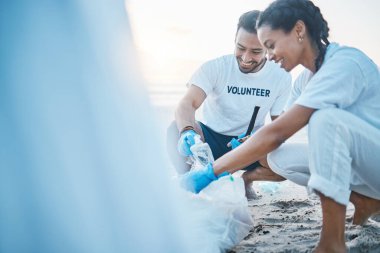 Gönüllü, manken ve dünya günü için plajı temizleyen insanlar. Doğal çevreye özen ve şefkat. Yardım, geri dönüşüm ve okyanus kumundaki plastik atık ve kirliliği toplayan mutlu erkek ve kadın.