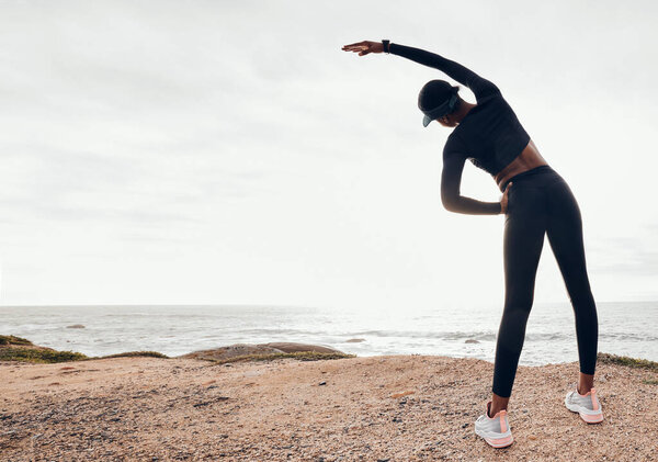 Back of woman stretching by ocean for fitness in nature for exercise, marathon training and running. Sports, mockup space and female person stretch arms for warm up, cardio workout and body wellness.