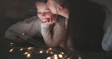 Tablet, aşk ve anne yatak odasında hikaye anlatmak, film izlemek ve yayınlamak için. Üyelik, online ve medya için aile evinde kadın ve kızla öpüşme, internet ve teknoloji.