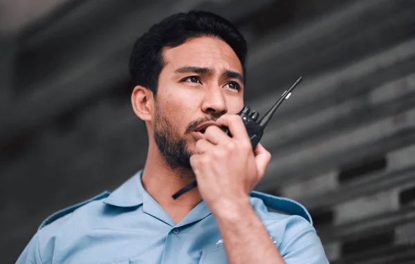 Walkie talkie, security guard or safety officer man outdoor for protection, patrol or watch. Law enforcement, transceiver and duty with a crime prevention male worker in uniform with communication.