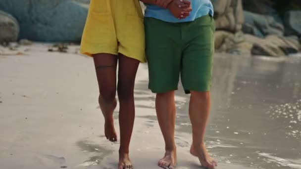 幸せなカップル 手を取り合って または自然の中で一緒に休憩するためにビーチで日没を歩く 海岸沿いの海沿いを歩く男と女の笑顔が上質な絆の時間とリラックスを楽しんで — ストック動画