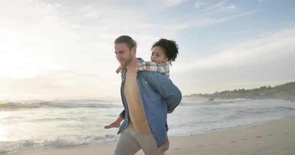 父亲和孩子在海滩搭便车度假或与人相处的乐趣 男人把跨种族的女孩背在背上 享受美好的时光 旅行和冒险去海边散步 — 图库视频影像