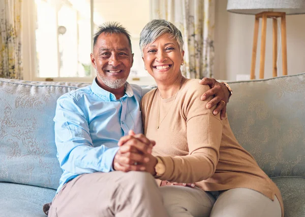 stock image Senior couple, portrait and holding hands on sofa in home living room, bonding and love. Smile, elderly man and happy woman relax with romance, care and enjoying retirement together in house lounge