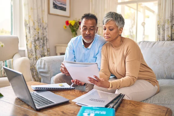 Laptop, documents and finance with a senior couple in the home living room for retirement or budget planning. Computer, accounting or investment savings with a mature man and woman in a house.